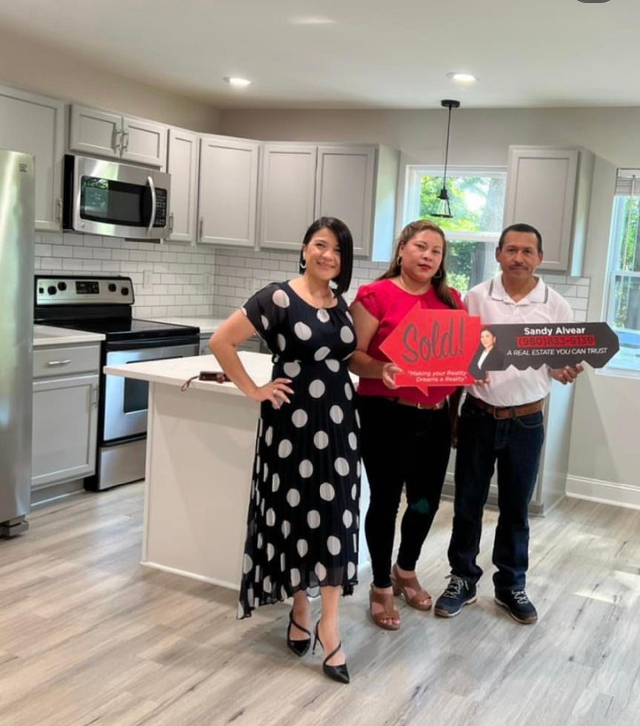 Sandy Alvear with clients at sold home kitchen interior